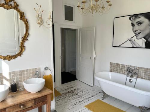 a bathroom with two sinks and a tub and a mirror at Domaine de la Course in Doudeauville