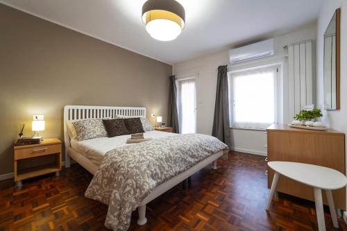 a bedroom with a bed and a table and a window at Casa Marlò Centro Storico in Cividale del Friuli