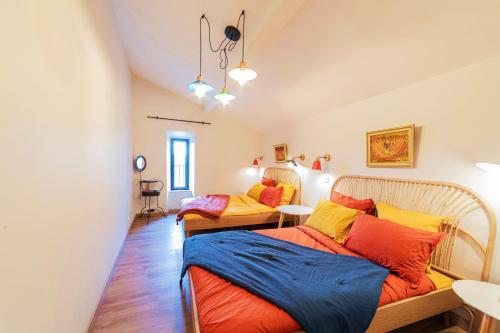 een slaapkamer met 2 bedden in een kamer bij Gîtes dans un mas en pierres au coeur d'un domaine viticole du Pic Saint-Loup in Corconne