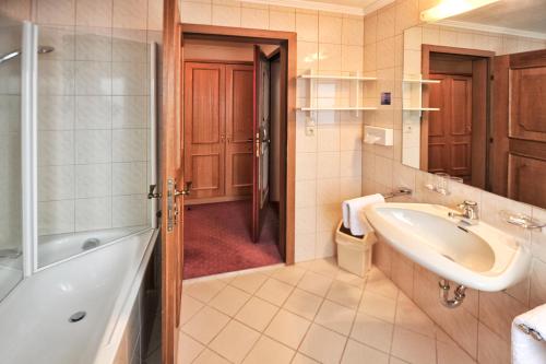 y baño con bañera, lavamanos y ducha. en Pension Timmelseck, en Obergurgl