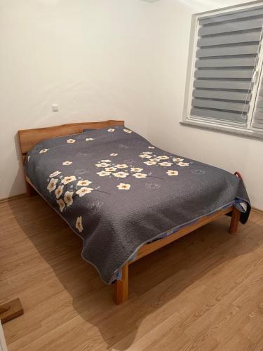 uma cama num quarto com um cobertor preto em MG em Žepče