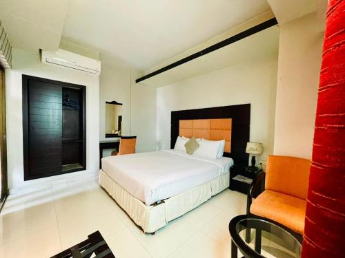 a bedroom with a large white bed and a window at Orchid Business Hotel in Chittagong
