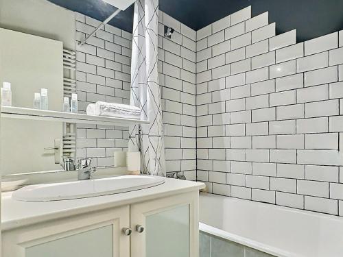 La salle de bains blanche est pourvue d'un lavabo et d'une baignoire. dans l'établissement 2 pièces, 4 pers, proche pistes/commerces, balcon, animaux acceptés - FR-1-411-775, à Tignes