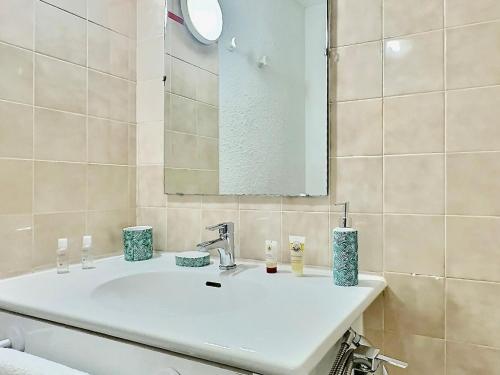une salle de bain avec un lavabo blanc et un miroir dans l'établissement Tignes Val Claret - Appartement cosy 4 pers., balcon, parking couvert - FR-1-411-464, à Tignes