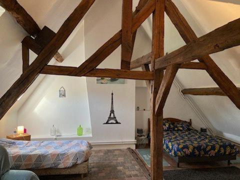 Zimmer im Dachgeschoss mit einem Bett und einem Turm in der Unterkunft Chambres d'hôtes chez Sylvie in Donnemain-Saint-Mamès