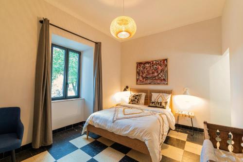een slaapkamer met een bed en een raam bij Gîtes dans un mas en pierres au coeur d'un domaine viticole du Pic Saint-Loup in Corconne