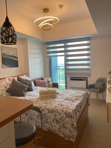 a bedroom with a large bed and a window at LeisureStay Studio @ Azure North in San Fernando
