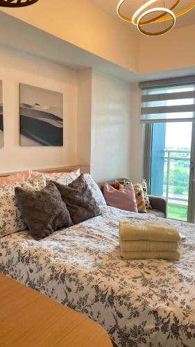a large bed in a room with a large window at LeisureStay Studio @ Azure North in San Fernando