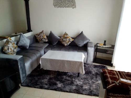 a living room with a couch and a table at شقة مفروشة in Temara