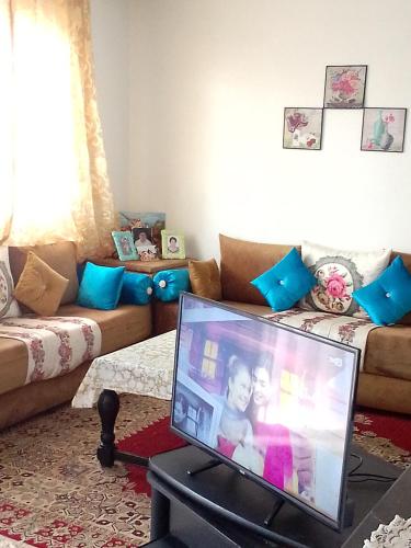 a living room with a tv and a couch at شقة مفروشة in Temara