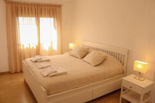 a white bedroom with a bed with towels on it at Beatriz (C): Tranquilidad y playa. in Breña Baja