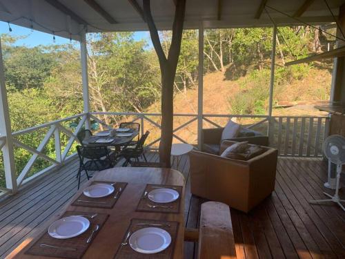 a porch with a couch and a table and chairs at Blue Container La Paillote in Paquera