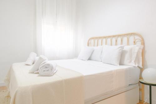 a white bed with white sheets and towels on it at For You Rentals Bonito y coqueto apartamento en Vallecas CAU231D in Madrid