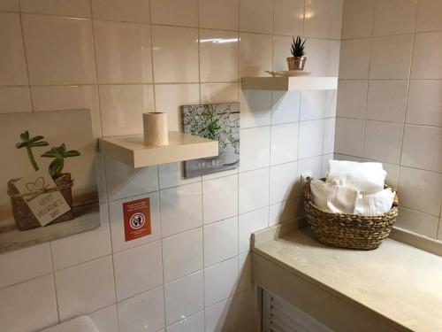 uma casa de banho com um cesto de toalhas num balcão em Gemini Apartment by AM no Funchal