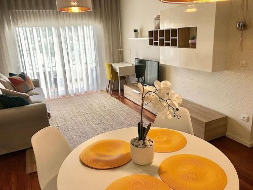 uma sala de estar com uma mesa com dois pratos em Gemini Apartment by AM no Funchal