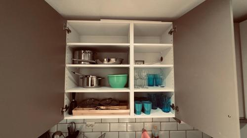 uma despensa de cozinha com prateleiras brancas com panelas e frigideiras em Rudnic Villa s Ap4 em Syfteland