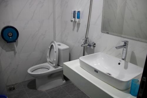 a white bathroom with a toilet and a sink at Minh Anh - Số 4 LK3 KDT Văn Phú - by Bay Hostel in Hà Ðông