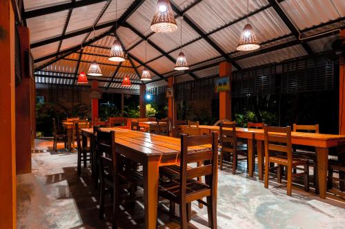 a restaurant with wooden tables and chairs and lights at Safari Lodge Yala in Kataragama
