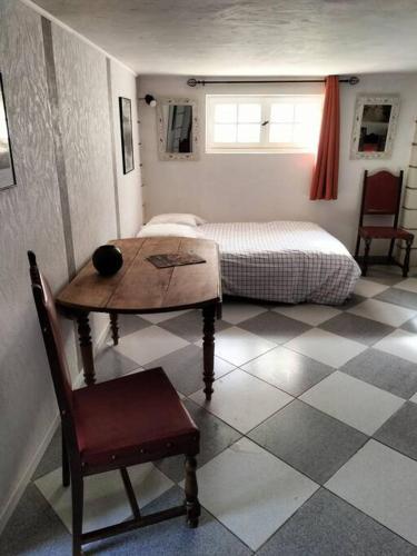 a bedroom with a table and a bed with a window at Charmant appart avec extérieur in Aigues-Mortes