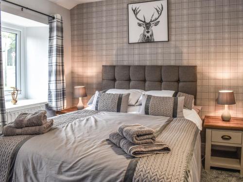 a bedroom with a large bed with towels on it at Gable End Cottage in Ingleton