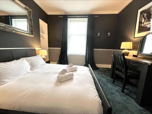 a bedroom with a bed and a desk and a window at Jardine Apartment @ Cairn Dhu House in Stornoway