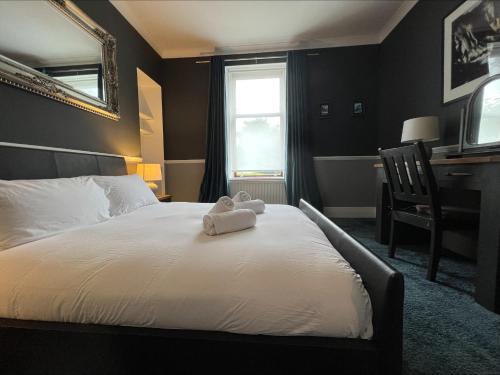 a bedroom with a bed with a teddy bear on it at Jardine Apartment @ Cairn Dhu House in Stornoway