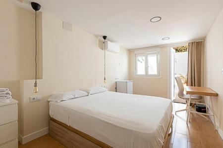 Un dormitorio con una gran cama blanca y una ventana en Oasis Urbano Ciudad Expo en Mairena del Aljarafe