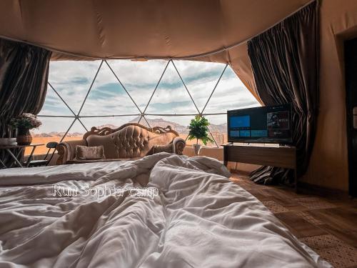 een slaapkamer met een bed en een groot raam bij Rum Sophia camp in Wadi Rum