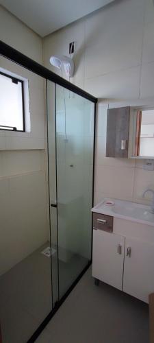 een badkamer met een glazen douche en een wastafel bij Sobrados in Torres
