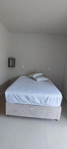 een wit bed in een witte kamer met een witte vloer bij Sobrados in Torres