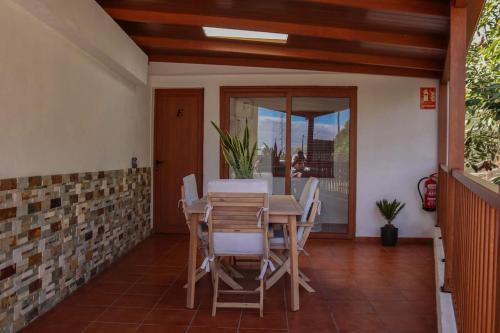 una sala da pranzo con tavolo e sedie su un patio di Mercedes (E): Campo y playa. a Breña Baja