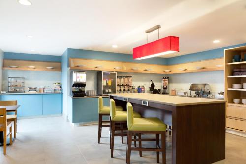 uma cozinha com paredes azuis e um balcão com bancos de bar amarelos em Country Inn & Suites by Radisson, Jackson, TN em Jackson