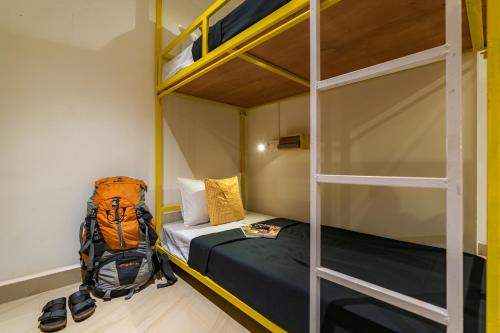 a bedroom with two bunk beds and a backpack at Whoopers Party Hostel, Palolem in Palolem