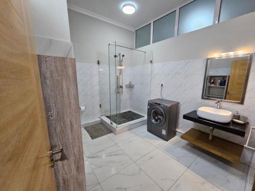 W łazience znajduje się prysznic, toaleta i umywalka. w obiekcie Beachfront Coziness w mieście Flic-en-Flac