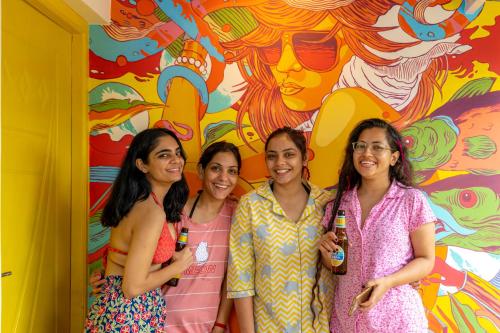 a group of women standing in front of a mural at Whoopers Party Hostel, Palolem in Palolem