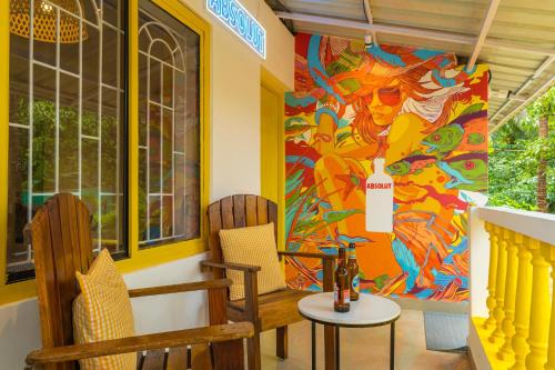 a room with two chairs and a colorful wall at Whoopers Party Hostel, Palolem in Palolem