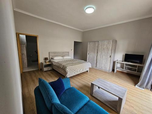 ein Wohnzimmer mit einem Bett und einem blauen Sofa in der Unterkunft Beachfront Coziness in Flic-en-Flac