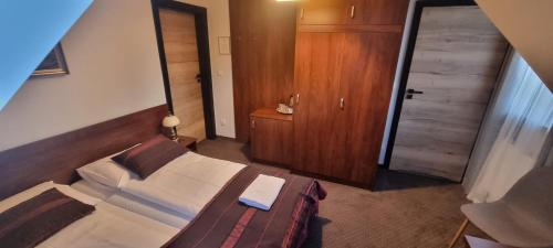 um quarto com uma cama com uma cabeceira de madeira e uma porta em Pensjonat Pod Długą Polaną em Nowy Targ