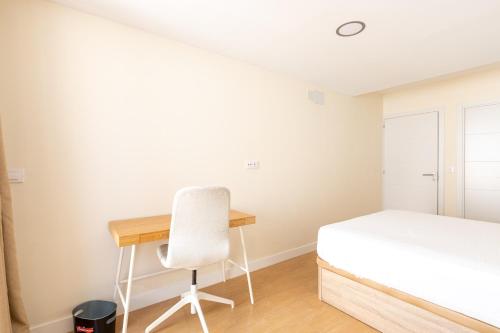 a bedroom with a desk and a bed and a chair at Oasis Urbano Ciudad Expo in Mairena del Aljarafe