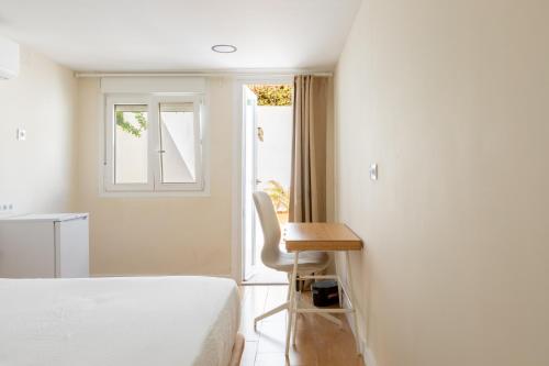 a bedroom with a bed and a desk and a window at Oasis Urbano Ciudad Expo in Mairena del Aljarafe