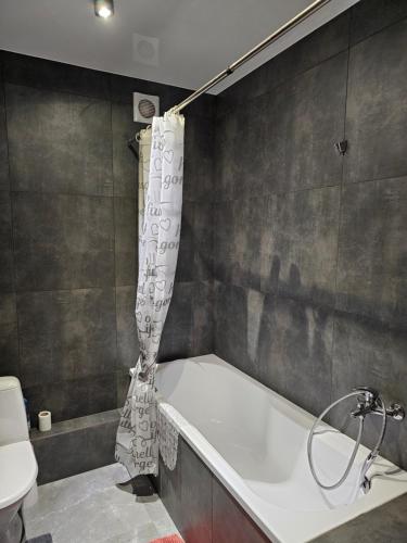 y baño con bañera y cortina de ducha. en Premium apartments 2, en Leópolis