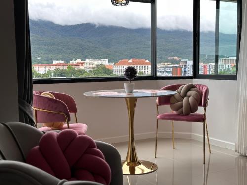 a room with chairs and a table in front of a window at Mountain & City View Panorama at Nimman in Chiang Mai