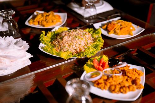 a table with several plates of food on it at Safari Lodge Yala in Kataragama