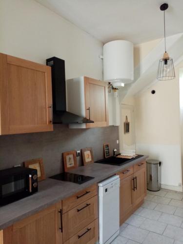 une cuisine avec des armoires en bois et un comptoir dans l'établissement Maison en plein cœur de ville à Montmorillon, à Montmorillon