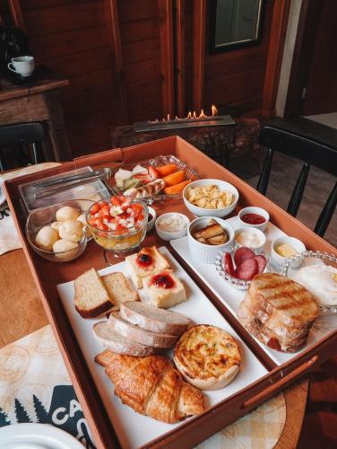 a tray filled with different types of food on a table at Pousada e Restaurante Casa Cida e Evandro in Gaspar
