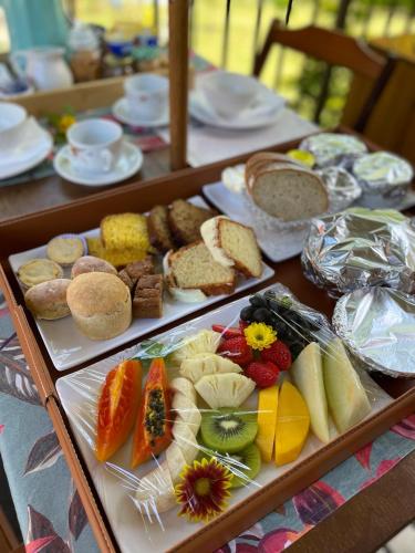 a table with two trays of different types of food at Pousada e Restaurante Casa Cida e Evandro in Gaspar