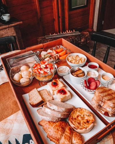 a table filled with different types of bread and other foods at Pousada e Restaurante Casa Cida e Evandro in Gaspar