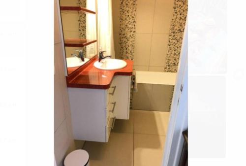 een badkamer met 2 wastafels en een bad bij Family appartment 200 meters from the beach in La Baule