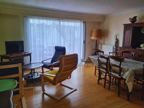 un salon avec une table et des chaises de salle à manger dans l'établissement Family appartment 200 meters from the beach, à La Baule