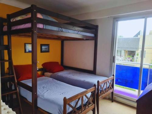 2 stapelbedden in een kamer met een raam bij Family appartment 200 meters from the beach in La Baule